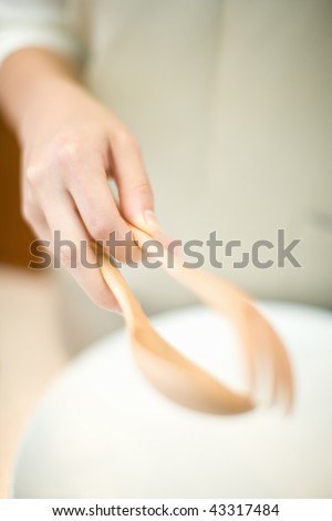 Man's hand with wooden spoon and folk