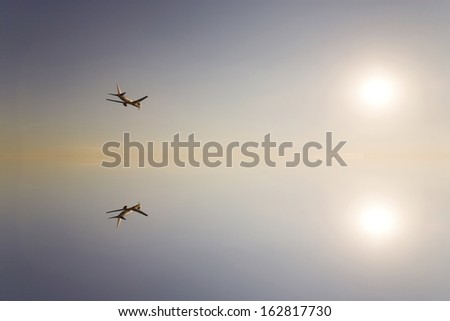 The sun and the passenger plane which are reflected in the water surface