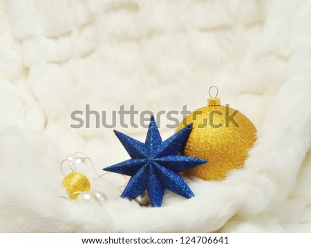 Christmas Decorations: star, balls and pearls on white fur with space for text writing