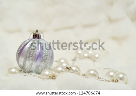 Christmas decorations with space for text writing: silver ball and pearls on the blurred background
