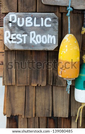 Public Rest Room Signage and hanging buoys at Crystal Cove California - a sleepy beach near Newport, CA.