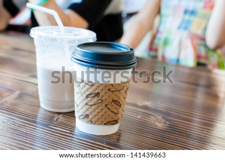 Cup of Coffee and Milk placed on table in cafe in front of people