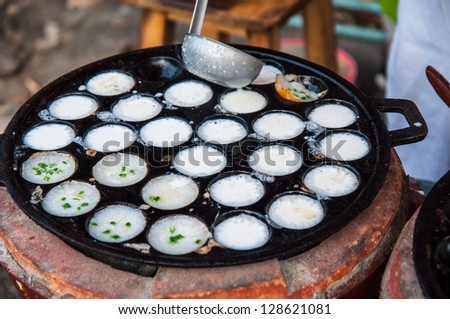 Women fill Coconut milk mix with powder on pan , Kind of Thai sweetmeat fried dessert