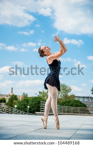 Ballet dancer dancing outdoor with blue sky in background