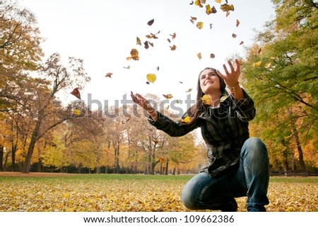 Happy life - woman throwing leaves in fall