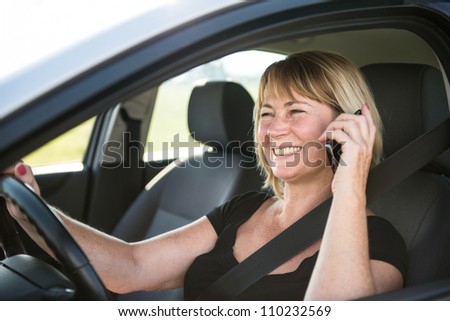 Lifestyle photo of attractive senior woman driving car and calling with mobile phone