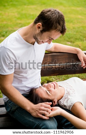 Young couple enjoying time together - woman lying on knees of man