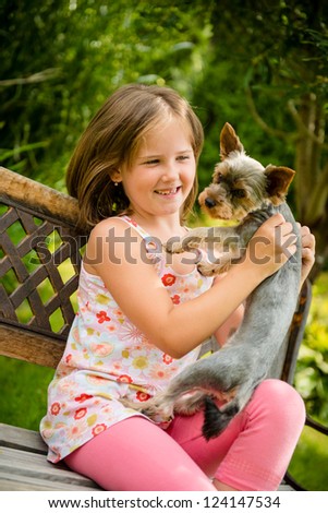 Happy smiling child playing with their pet - outdoor in backyard