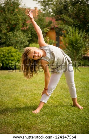 Sporting on grass - smiling little child exercising outdoor in backyard