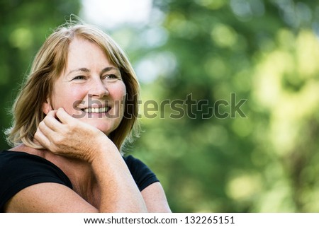 Portrait of happy smiling senior woman - outside on sunny day