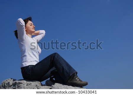 Young attractive woman with face turned against sun in mountains