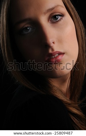 Portrait of young beautiful woman on black background