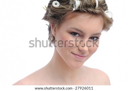Young beautiful woman with hair rollers in curls isolated on white