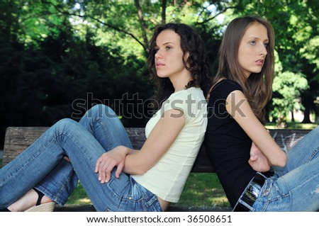 Friends outdoors series - two teenage girls are in conflict and do not speak with each another