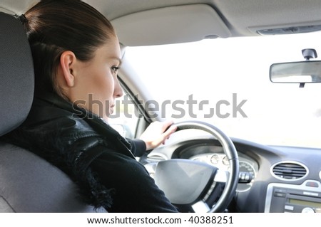 Young woman driving car - rear view on person and window