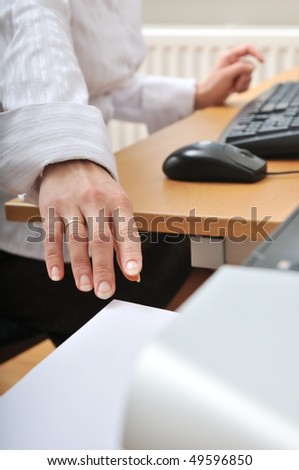 Hand of business woman reaching paper from printer on workplace - detail