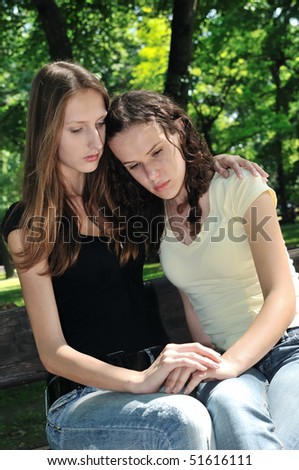 Friends - one teenage girl comforts another which has serious problem