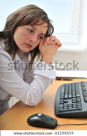 Young frustrated and depressed business person (woman) sitting at table with computer