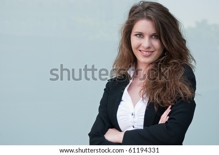 Young smiling business woman - portrait against plain glass background