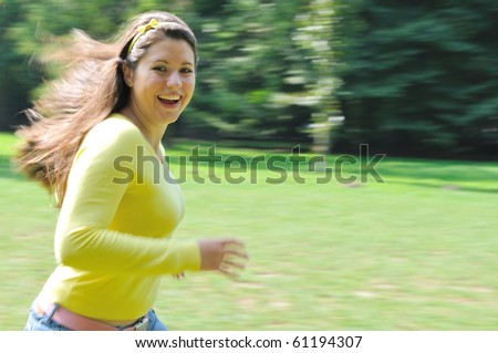 stock photo Panning shot of teenage girl running in park