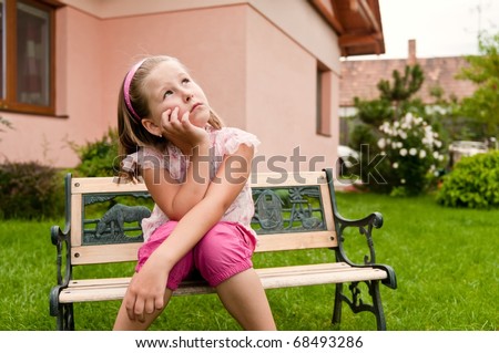 Girl having big problems - sitting on bench in backyard with family house behind