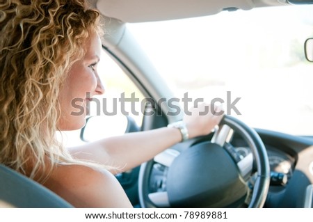 Portrait of young smiling woman driving car