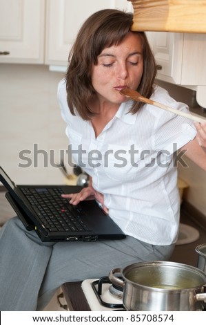 Multitasking woman - cooking meal and working