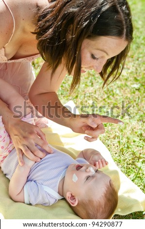 Mother gives sun protection to baby