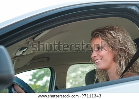 Portrait of young smiling person driving car