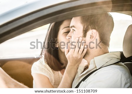 Couple in love - woman kissing man in car while driving