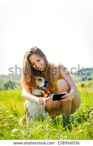 Teen Girl Showing Something To Her Dog On Smart-Phone, Outdoor In Nature