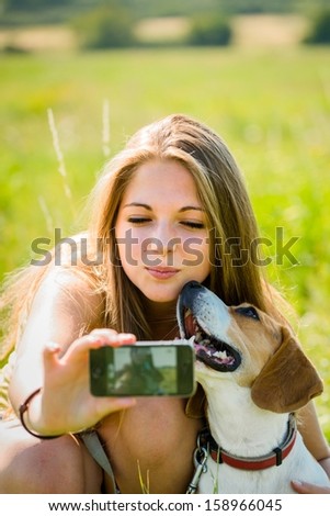 Teen Girl Taking Photo Of Herself And Her Dog With Mobile Phone Camera