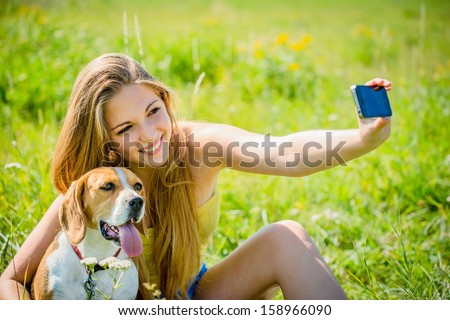 Teen Girl Taking Photo Of Herself And Her Dog With Mobile Phone Camera