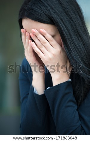 Portrait of young depressed woman - hands on face