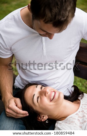 Young couple enjoying time together - woman lying on knees of man