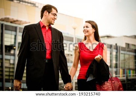 Young smiling business couple walking street after their work