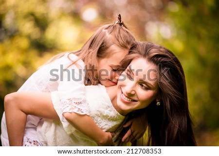 Happy mother having great time together with her daughter in nature