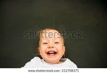 Portrait of laughing baby with standing hair from static electricity
