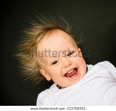 Portrait of laughing baby with standing hair from static electricity