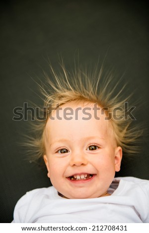 Portrait of smiling baby with standing hair from static electricity