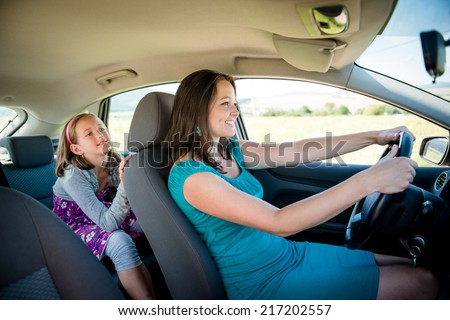 Mother driving car and child sitting on back seat - no belt, dangerous