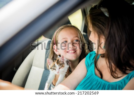 Mother and child with kitten having fun in car