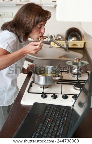 Multitasking woman - cooking meal and working