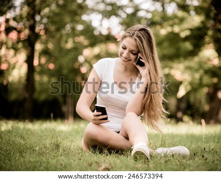 Young beautiful woman (teen girl) with 2 mobile phones - mobility concept