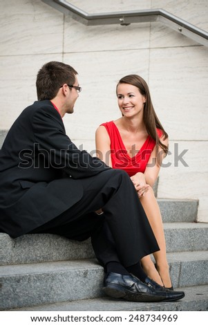 Colleagues - young business people having conversation sitting on stairs