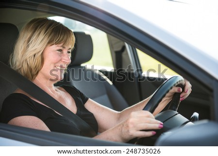 Lifestyle photo of attractive senior woman driving car