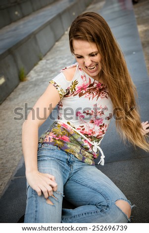 Young woman pretending tiger and tearing up jeans