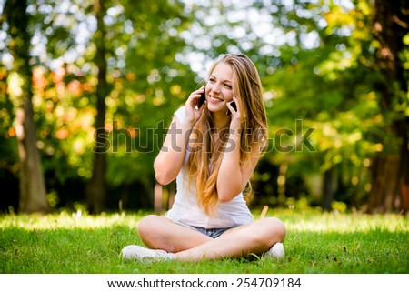 Technology in excess - teen girl calling with 2 mobile phones outdoor