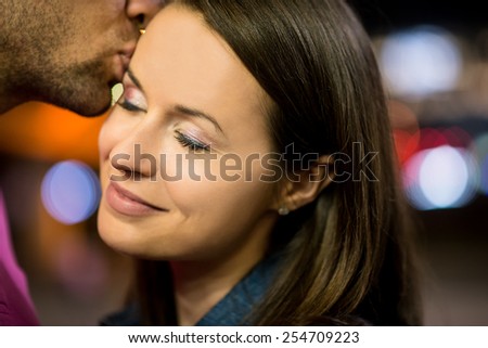 Romantic young couple together on date in street at night