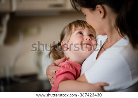 Mother and daughter embracing indoors at home